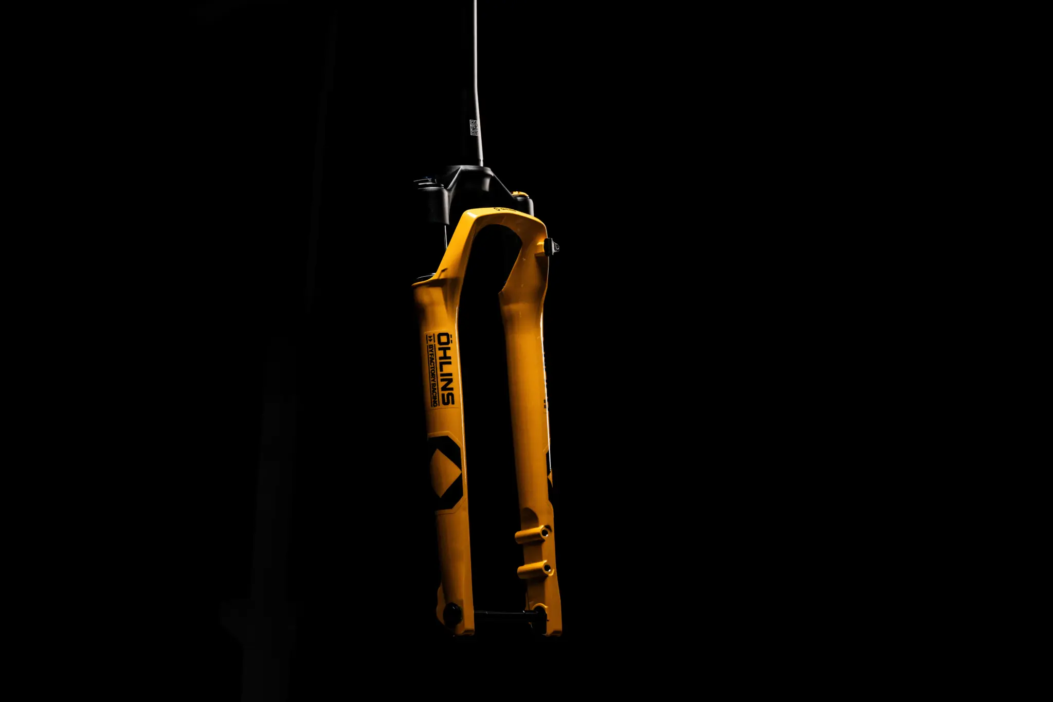 Yellow Öhlins GXF30 M.1 fork photographed on its own against a black background